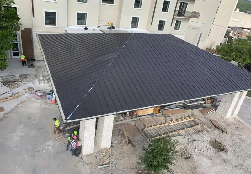 Metal roofing installation team working on a commercial building in Galveston